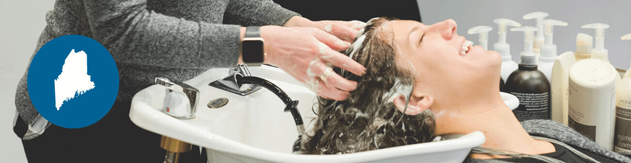 Female hairdresser washing customers hair